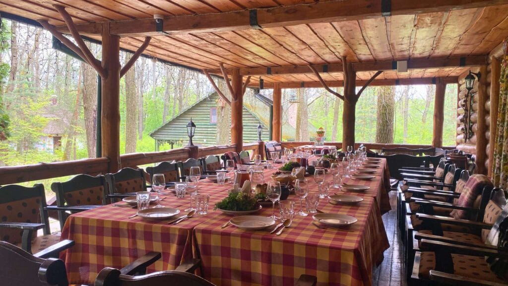 Тераса ресторану «Рудий Лис» у Лісотелі з накритими столами серед лісу